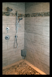 Custom shower with pebble stone floor and custom foot rest for new master suite in residence in Charlottesville, Virginia, designed by Candace M.P. Smith Architect